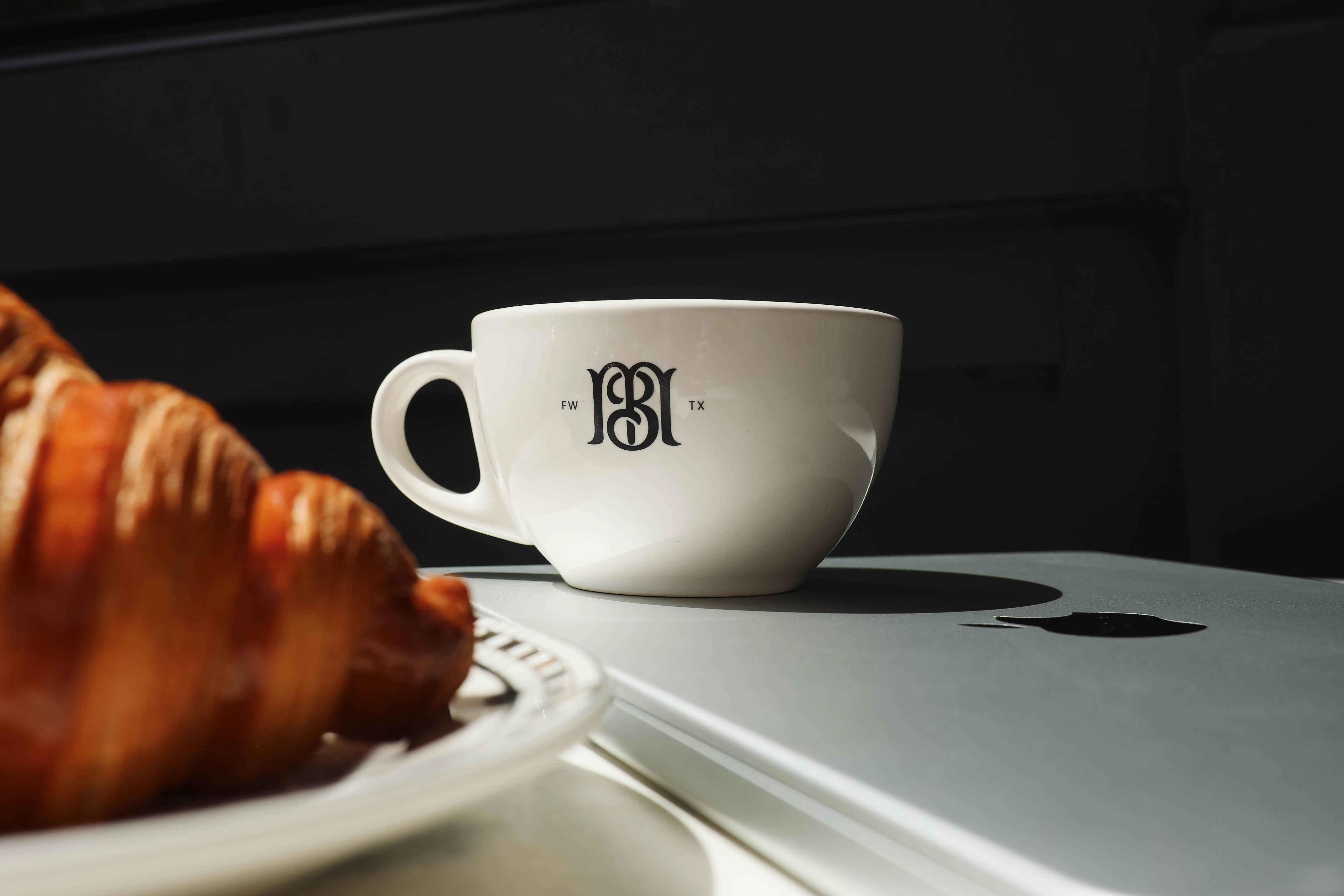Marché Bleu monogram mug beside a fresh croissant
