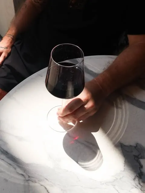 A glass of red wine in the afternoon light on the marble table